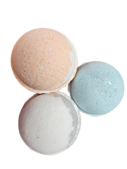 Three bath bombs in beige, gray, and light blue on a white background