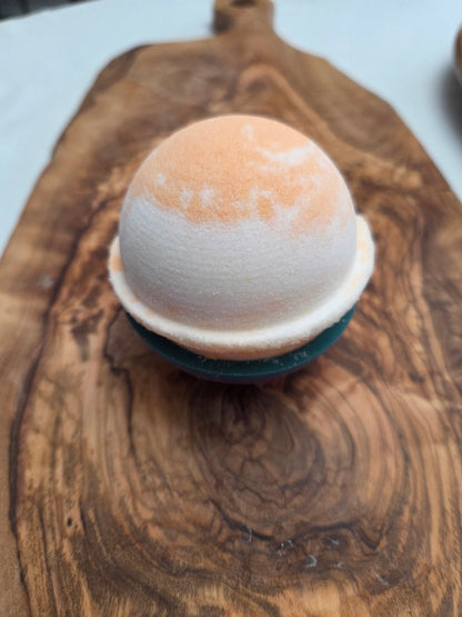 Orange and white bath bomb in Sweet Orange essential oil scent on a wooden surface to show