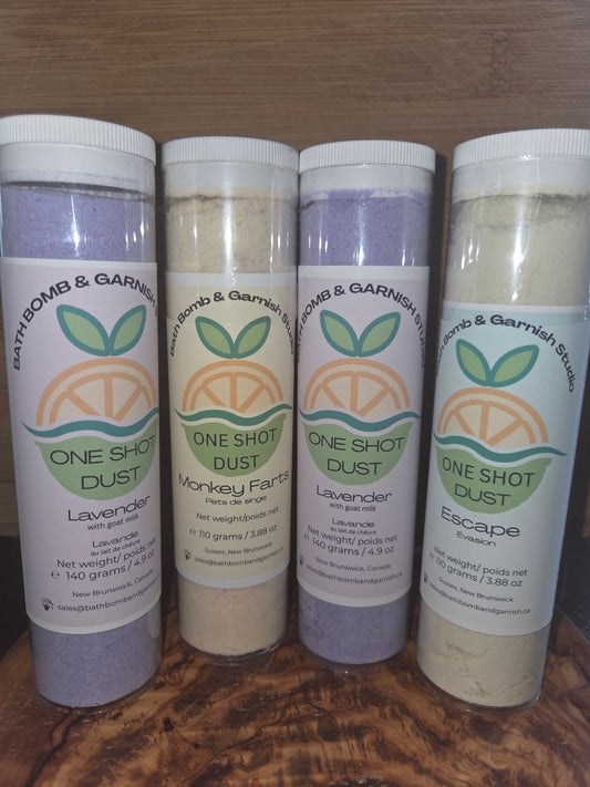 Picture of Four  cylindrical containers  110-140 grams each Bath Bomb Dust in assorted fragrances, Lavender, Monkey farts and Escape o a wooden surface to show