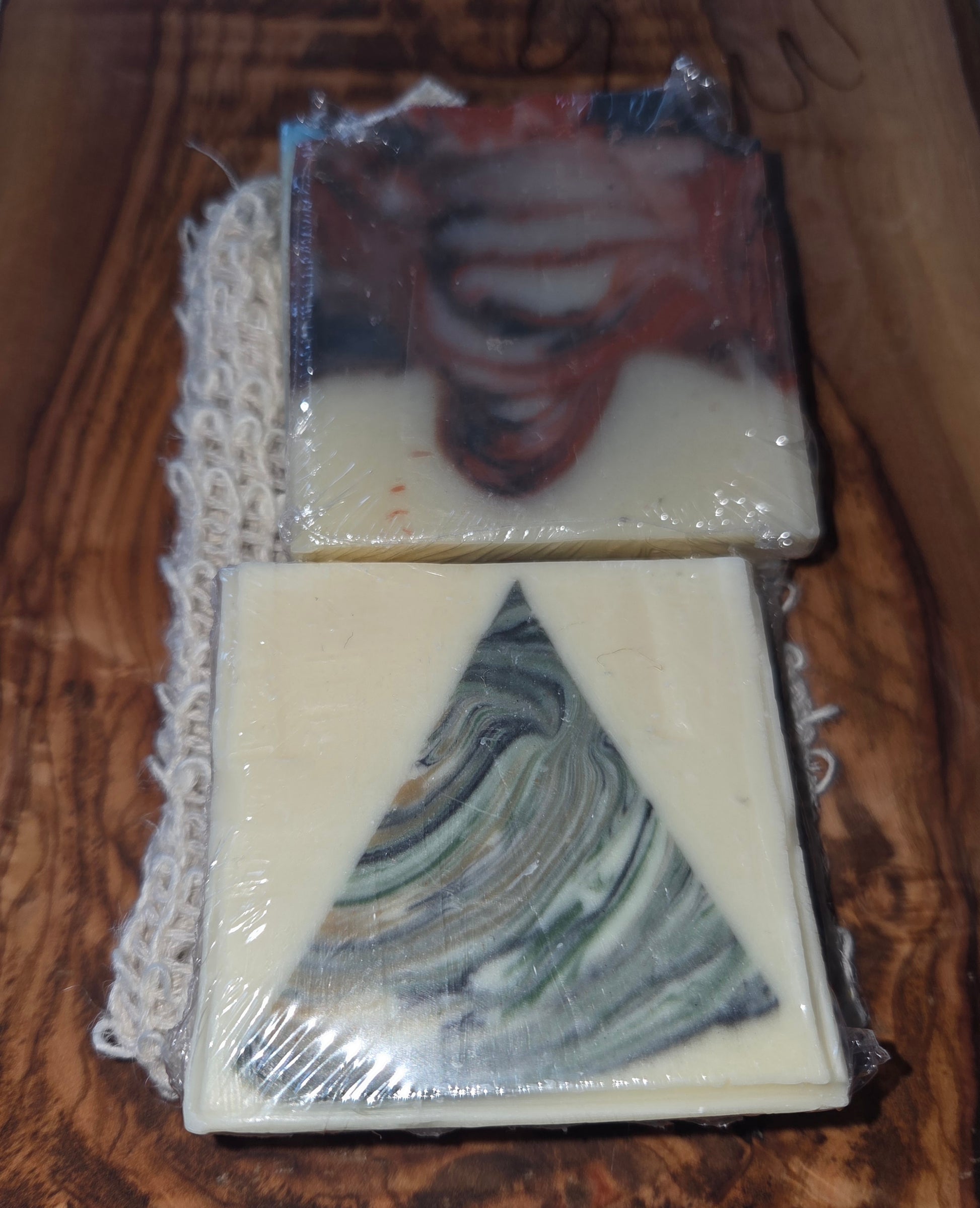Two bars of soap showing, 4 bars in total with marbled design on a wooden surface. Comes with a sisial bag.