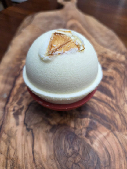 Light Yellow Bath bomb  in Lemon essential oil scent with 1-
/4 lemon slice on a wooden surface